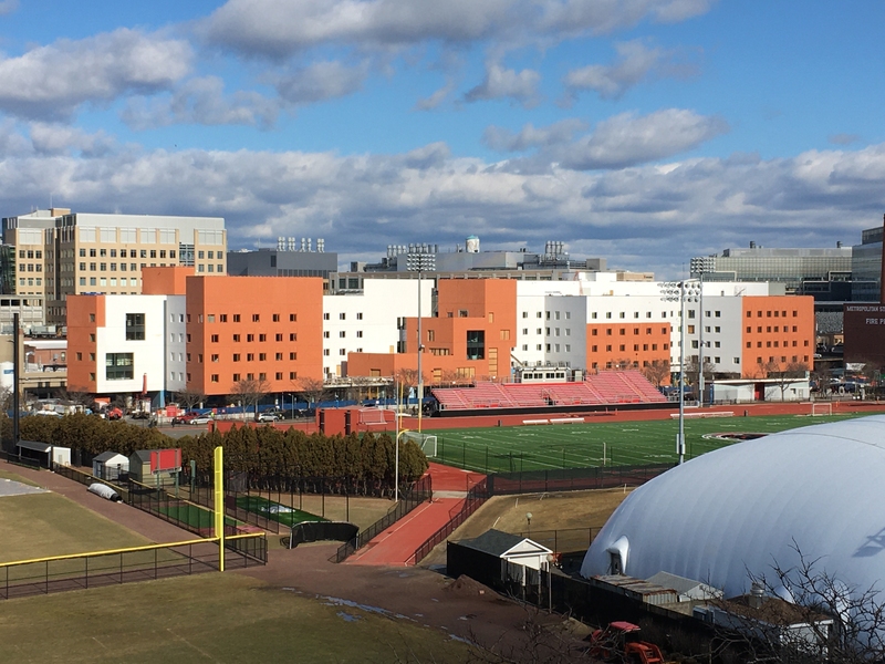 Photo of the exterior of W46, whose facade features alternating blocks of peach-colored and white brick Caption:New Vassar, a 450-bed community that opened in January, was developed through a collaborative process that identified student priorities and sought new ways to improve the living experience. The building houses a mix of first-year and upper-level students within clusters, each encompassing single and double rooms, a study room, and a lounge space. Photo: MIT Facilities