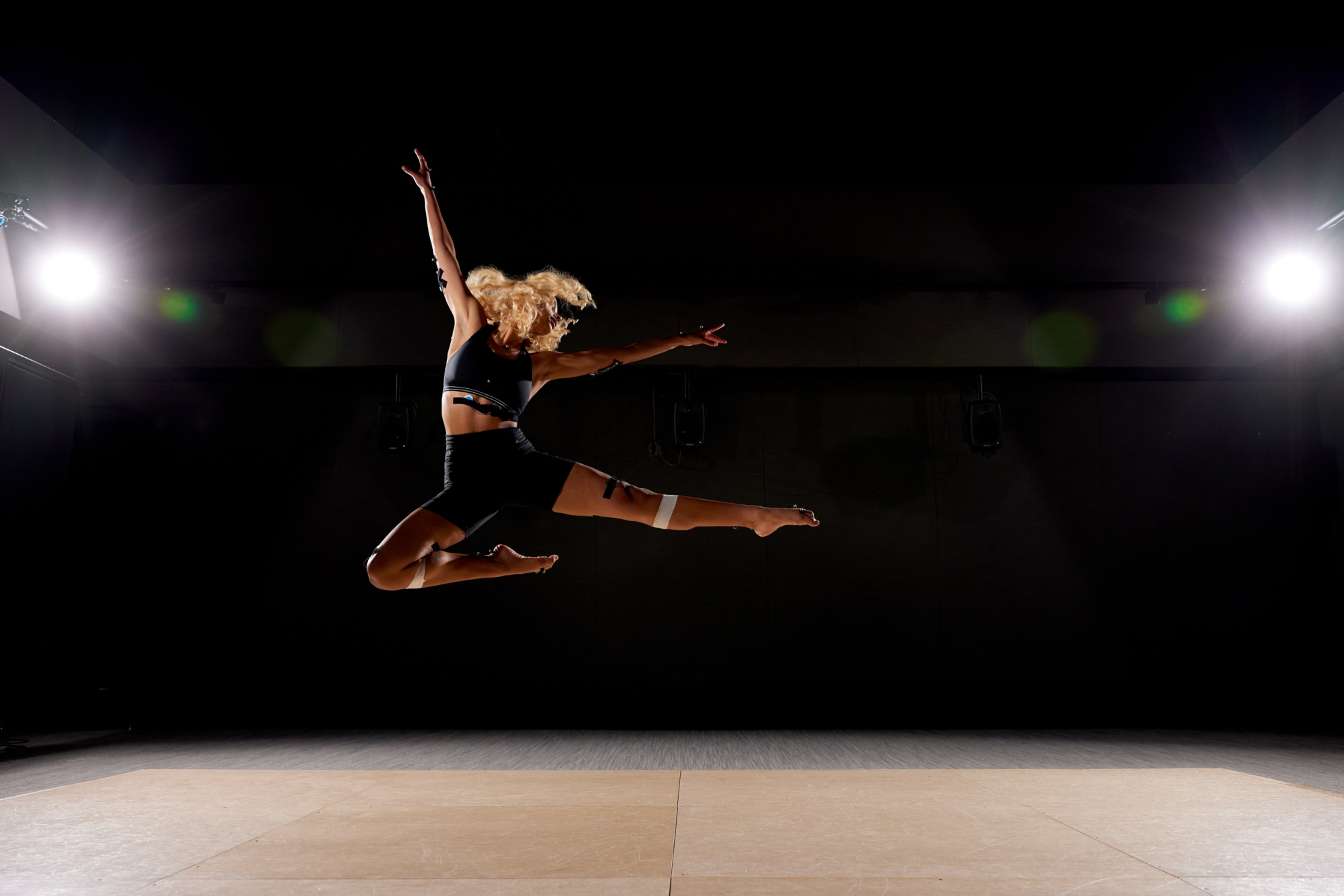 Kaelyn Dunnell ’25 executes a dance move known as a “stag jump,” as directed by undergraduate researcher Izzi Waitz ’23, while MIT.nano researchers track her movements.